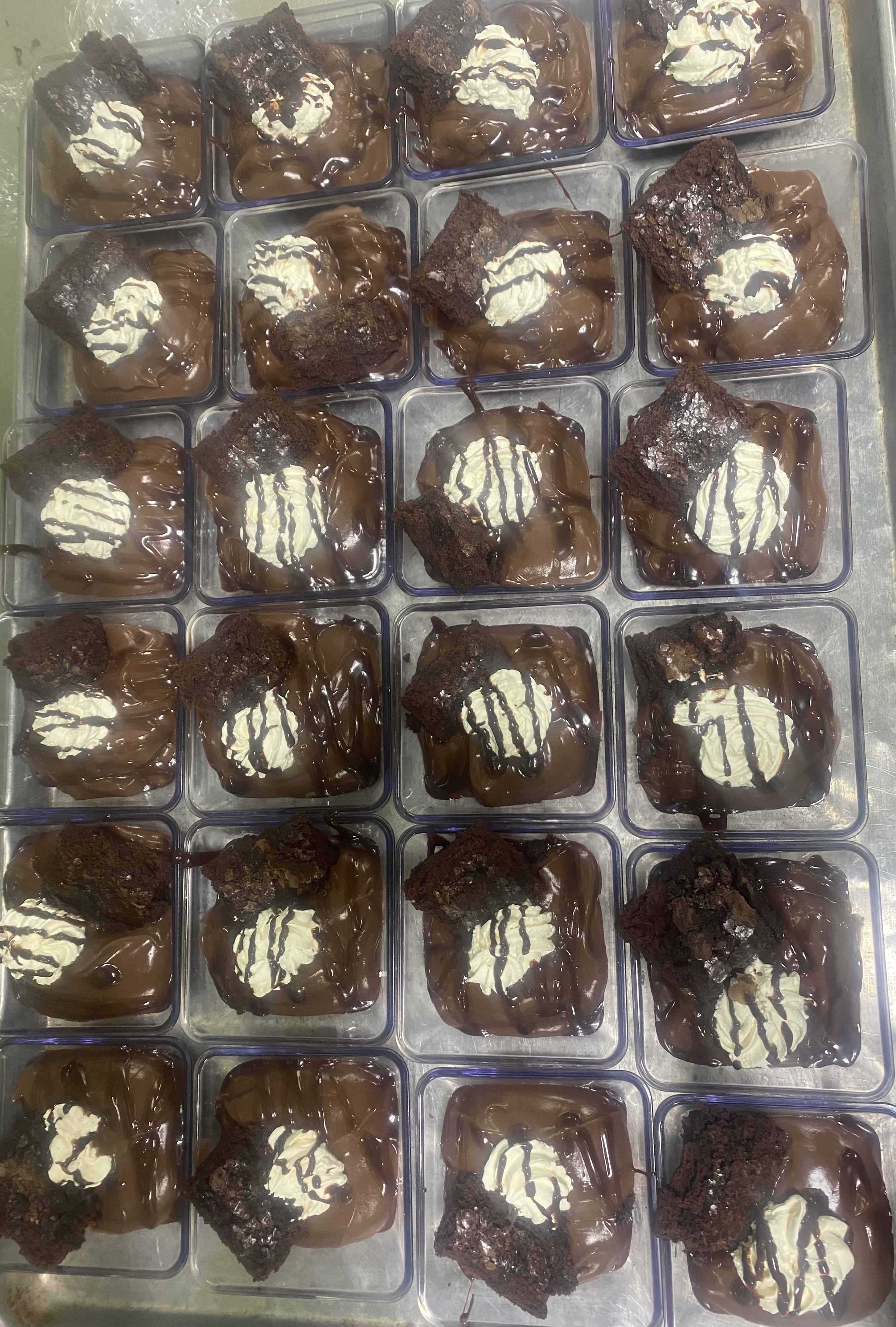 Chocolate Pudding With A Whipped Cream Topping With Chocolate Sauce With Side Of Fudge Brownie