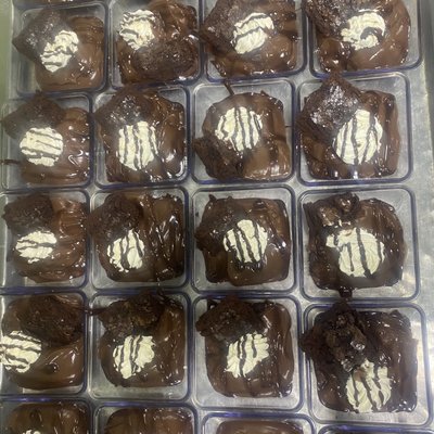 Chocolate Pudding With A Whipped Cream Topping With Chocolate Sauce With Side Of Fudge Brownie
