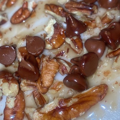 Almond Cake w/ Buttercream Frosting Topped With Chocolate Chips Pecans Caramel Sauce